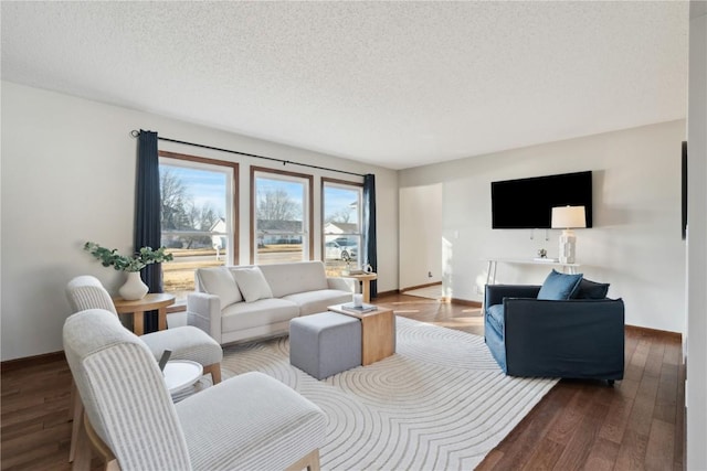 living area featuring a textured ceiling, wood finished floors, and baseboards