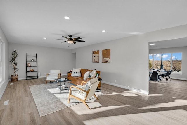 living area featuring light wood-type flooring, ceiling fan, baseboards, and recessed lighting