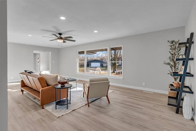 living room featuring a ceiling fan, recessed lighting, light wood-style flooring, and baseboards