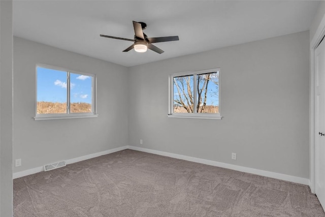 unfurnished bedroom with a ceiling fan, carpet, visible vents, and baseboards