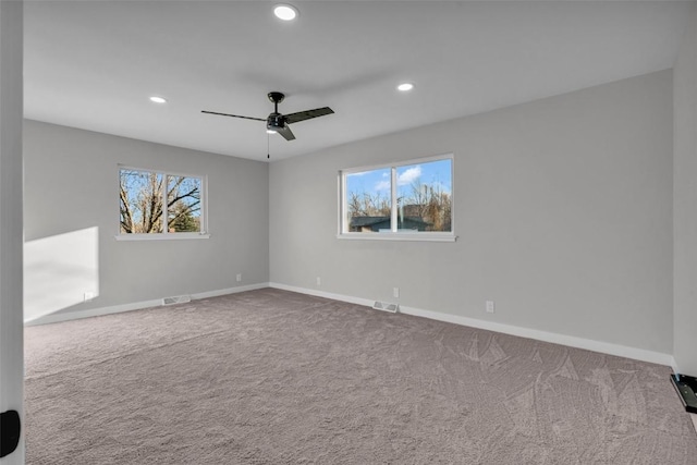 carpeted empty room with ceiling fan, recessed lighting, visible vents, and baseboards