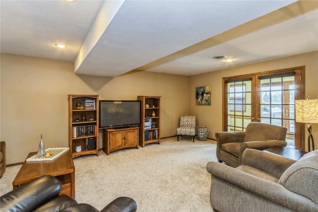 living room with visible vents, light colored carpet, french doors, and baseboards