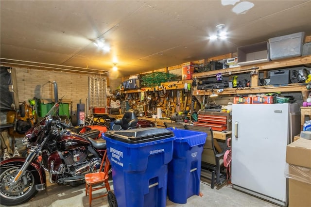 garage with a workshop area and freestanding refrigerator