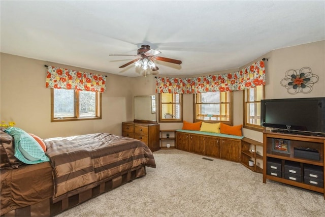 carpeted bedroom with visible vents and multiple windows