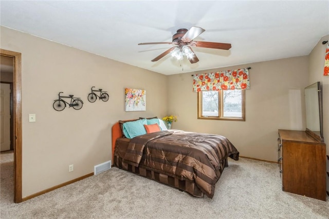 carpeted bedroom featuring a ceiling fan, visible vents, and baseboards