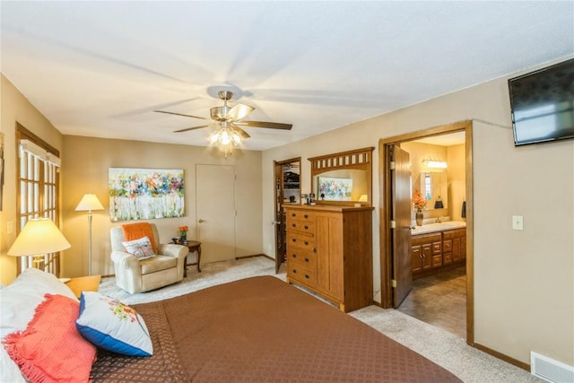 carpeted bedroom with visible vents, baseboards, ceiling fan, and ensuite bathroom