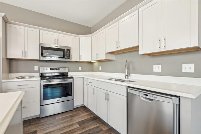 kitchen featuring stainless steel appliances, light countertops, dark wood-type flooring, white cabinetry, and a sink