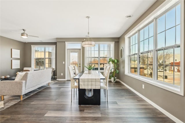 dining area featuring dark wood-type flooring, plenty of natural light, and baseboards