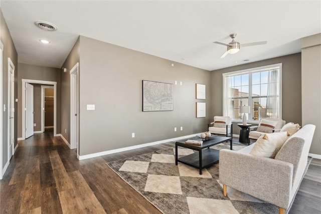 living room featuring visible vents, baseboards, and wood finished floors