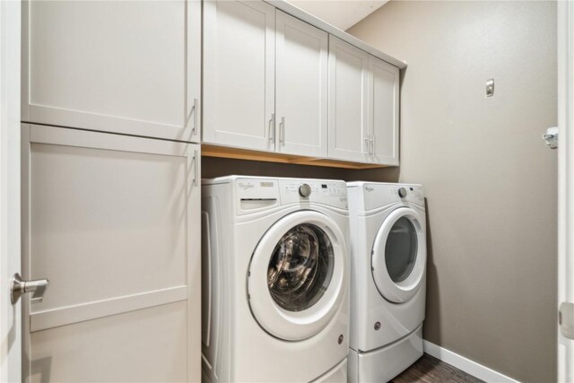 laundry room with washer and clothes dryer, cabinet space, and baseboards