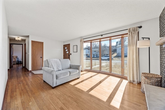 living area featuring a textured ceiling and wood finished floors