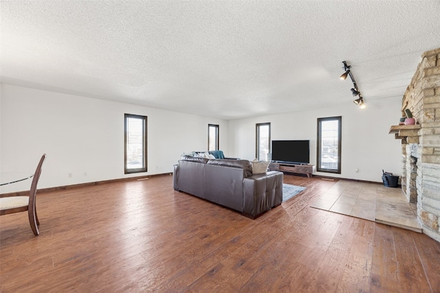 living room with a fireplace, a textured ceiling, and hardwood / wood-style floors