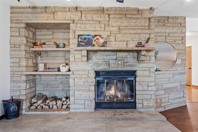 details with a textured ceiling and a stone fireplace