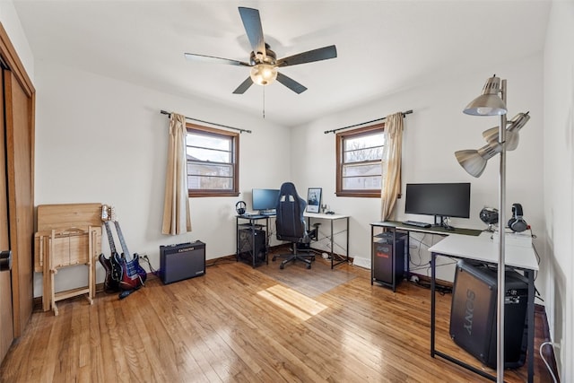 home office with a ceiling fan, baseboards, a healthy amount of sunlight, and light wood finished floors