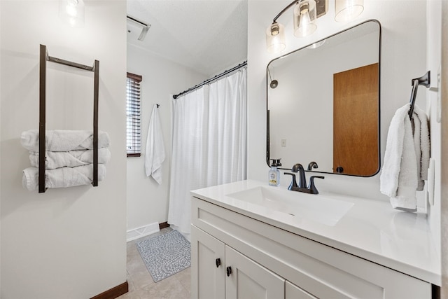 full bathroom featuring a shower with shower curtain, tile patterned floors, baseboards, and vanity