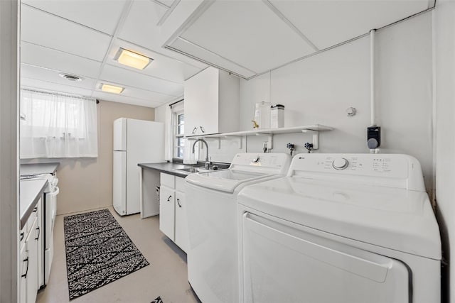 washroom with independent washer and dryer, a sink, visible vents, and a healthy amount of sunlight