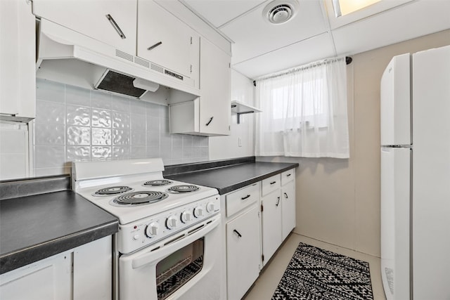 kitchen featuring under cabinet range hood, white appliances, white cabinetry, visible vents, and dark countertops