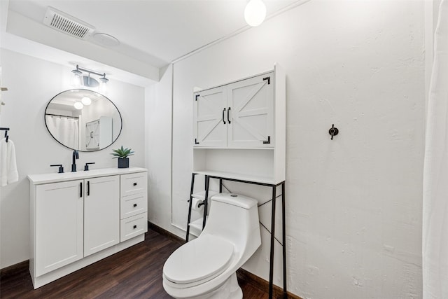 bathroom with visible vents, vanity, toilet, and wood finished floors