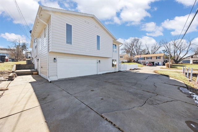 view of side of home with driveway and a garage