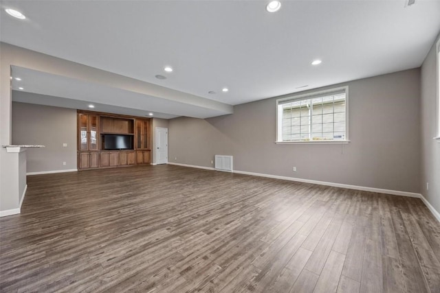 unfurnished living room featuring recessed lighting, dark wood-style flooring, visible vents, and baseboards