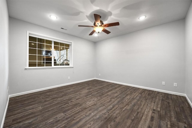 spare room featuring recessed lighting, dark wood-style flooring, a ceiling fan, visible vents, and baseboards