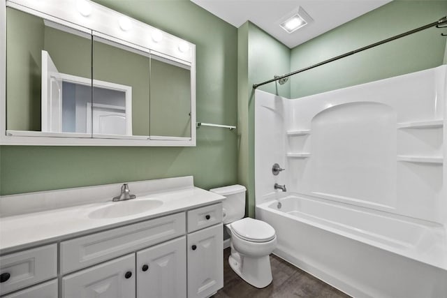 full bath with toilet, bathtub / shower combination, wood finished floors, and vanity