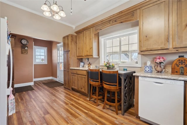 kitchen with crown molding, light countertops, light wood-type flooring, white appliances, and baseboards