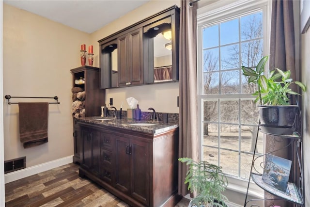 bar with visible vents, baseboards, dark wood finished floors, and a sink