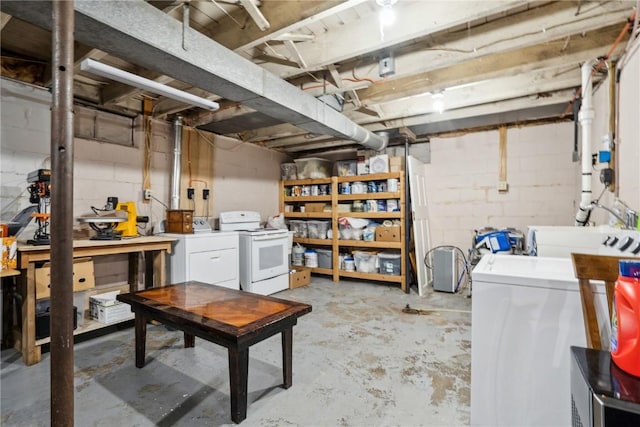 unfinished basement featuring concrete block wall and independent washer and dryer