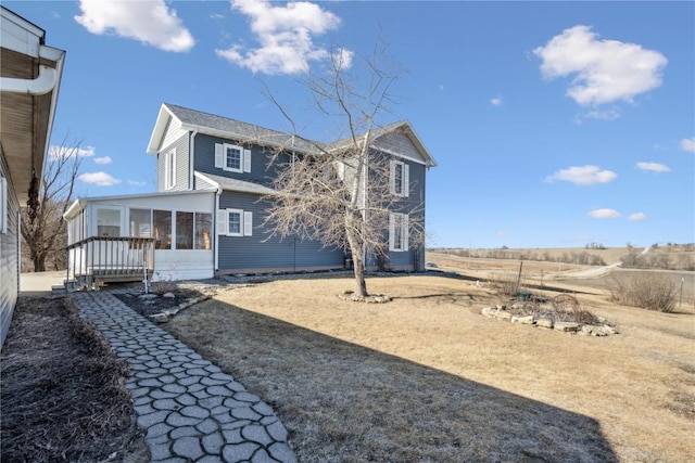 rear view of property featuring a sunroom