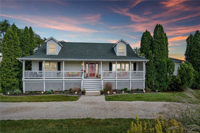 view of front of home featuring covered porch, a front lawn, and roof with shingles