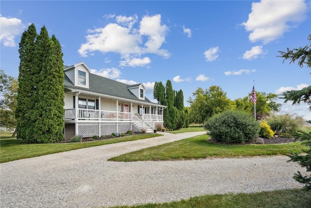 view of front of house with driveway, covered porch, and a front lawn