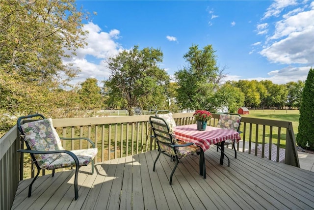 wooden deck with outdoor dining space and a yard