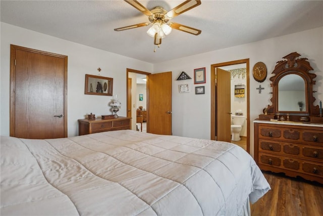 bedroom with connected bathroom, a closet, ceiling fan, and wood finished floors