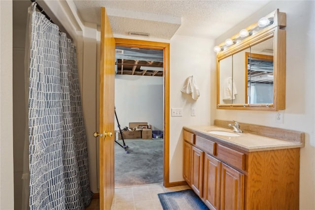 bathroom featuring visible vents, a textured ceiling, and vanity