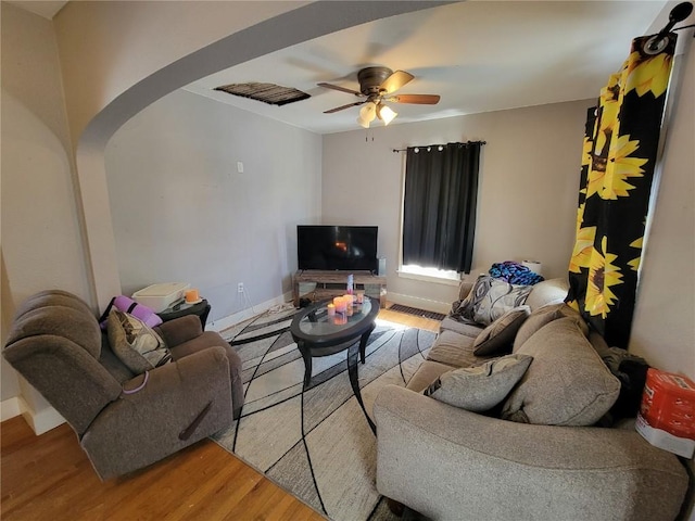 living room featuring baseboards, visible vents, arched walkways, ceiling fan, and wood finished floors