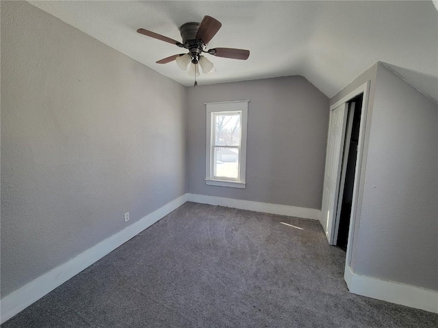 additional living space featuring carpet, a textured wall, vaulted ceiling, ceiling fan, and baseboards