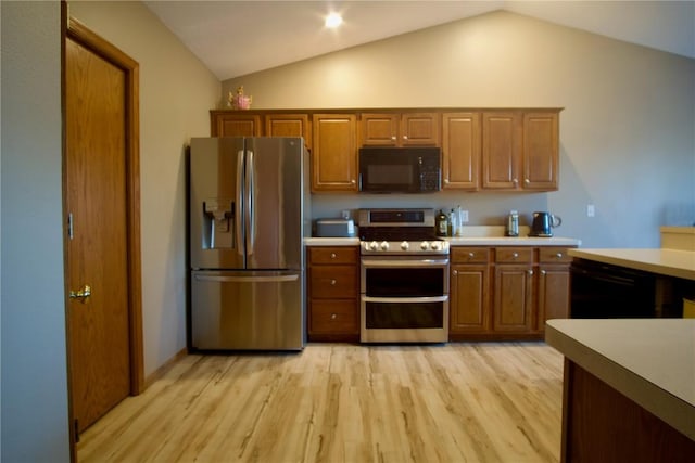 kitchen with lofted ceiling, black appliances, light wood-style flooring, and brown cabinets