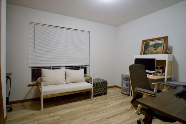 home office with light wood-style flooring and baseboards