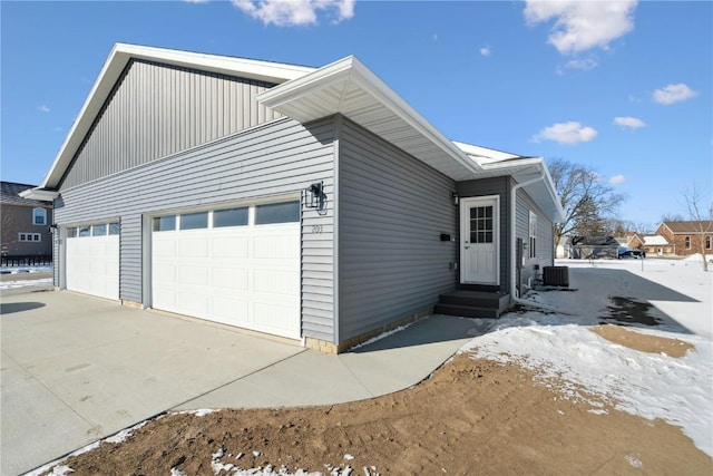 view of front of home featuring a garage, entry steps, central AC, and driveway