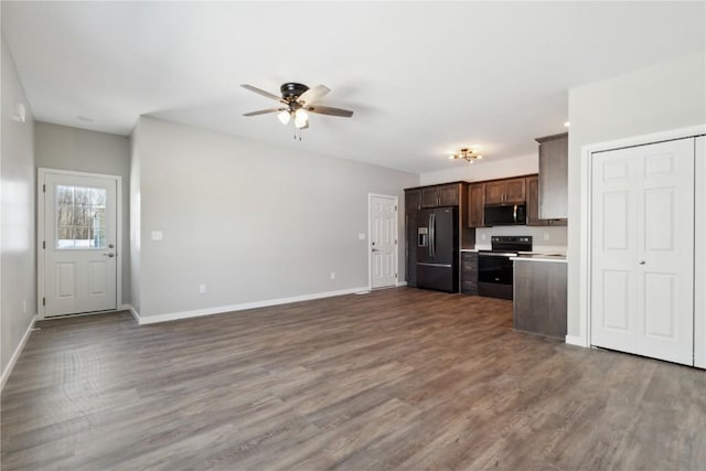 kitchen featuring dark wood-style flooring, electric range oven, dark brown cabinetry, baseboards, and black fridge