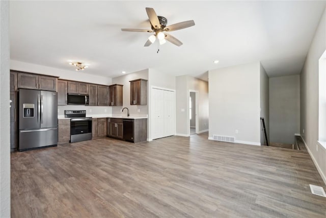 kitchen with wood finished floors, a sink, visible vents, light countertops, and appliances with stainless steel finishes