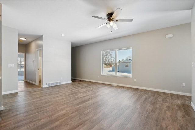 unfurnished living room featuring visible vents, baseboards, and wood finished floors