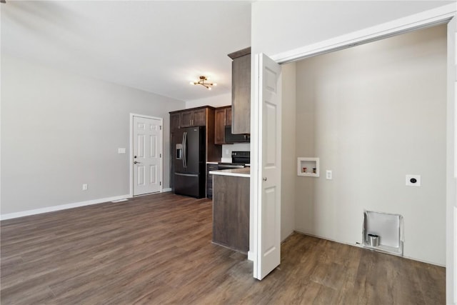 kitchen featuring dark wood-style floors, light countertops, dark brown cabinetry, black appliances, and baseboards