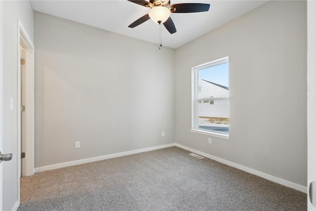 carpeted spare room with ceiling fan, visible vents, and baseboards