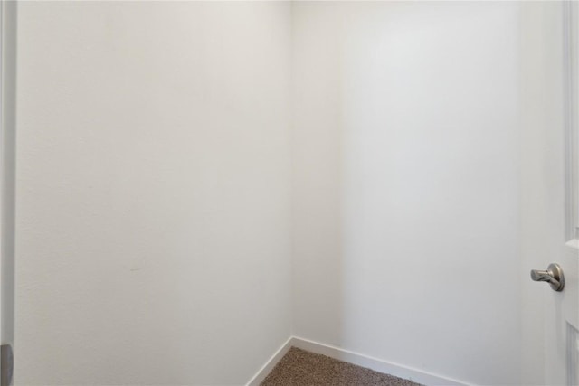 walk in closet with dark carpet