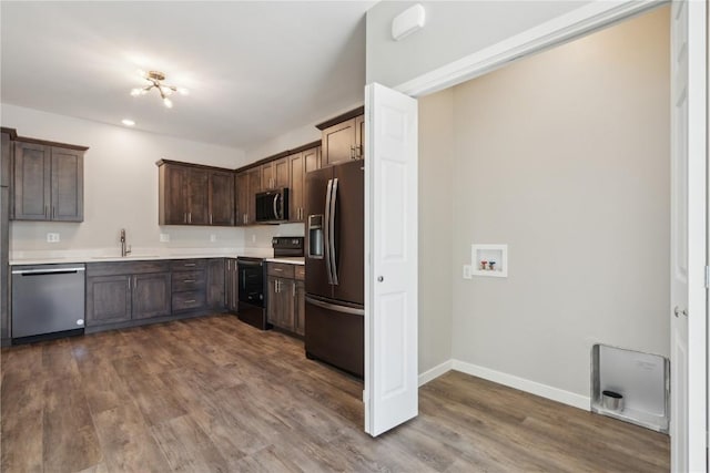 kitchen featuring dark wood-style flooring, stainless steel appliances, a sink, and light countertops