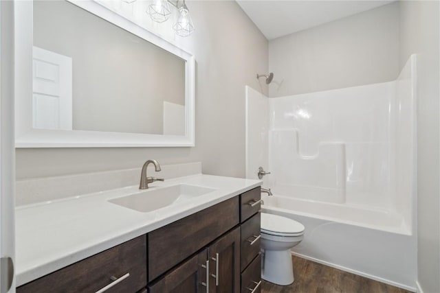 bathroom with vanity, shower / bathing tub combination, wood finished floors, and toilet