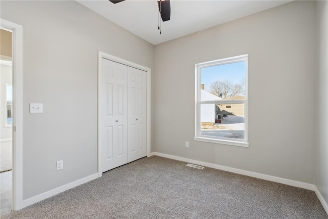 unfurnished bedroom with carpet flooring, visible vents, and baseboards