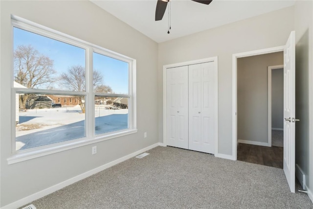 unfurnished bedroom featuring a closet, visible vents, carpet flooring, ceiling fan, and baseboards